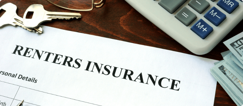 Renters insurance contract next to a calculator and cash.
