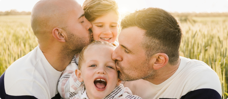 A happy family embracing for a cute family photo on a sunny day.