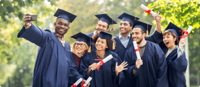 A group of happy university graduates posing for a selfie.
