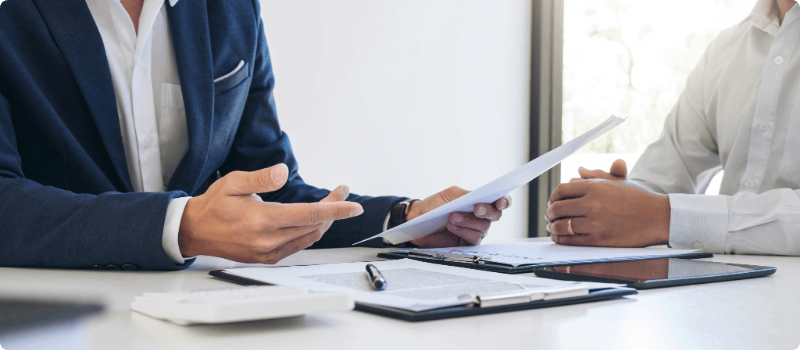 Two people discussing a document at a desk.