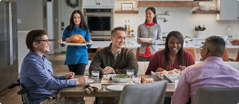 Family and friends sitting at a table having dinner.
