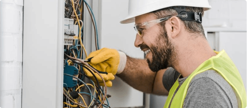 Happy construction worker fixing circuit breaker.