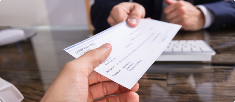 One person handing another person a check.