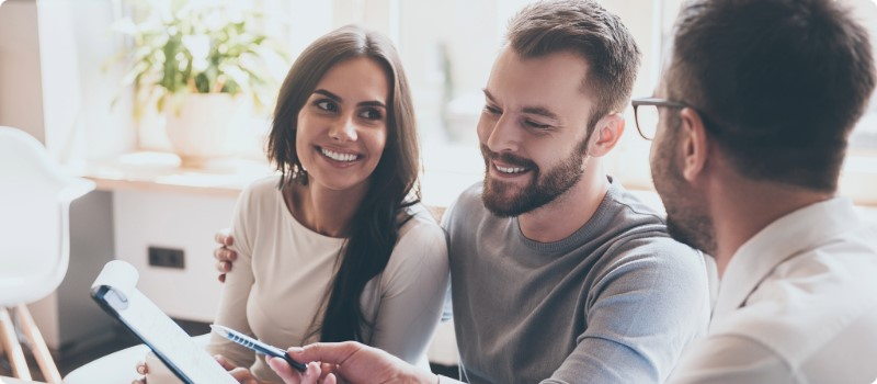 A couple reviewing documents with a realtor.