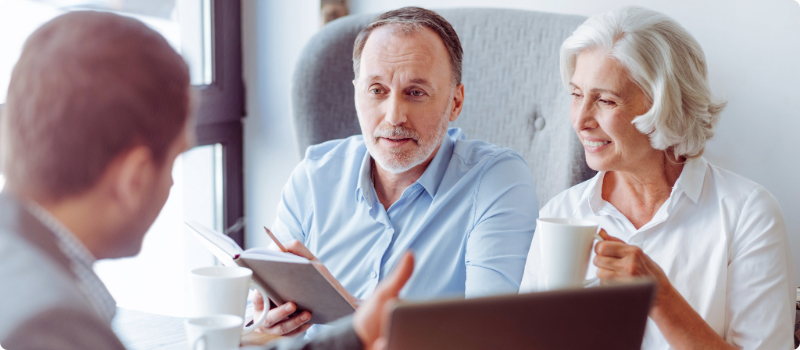 A couple speaking with a realtor in an office.