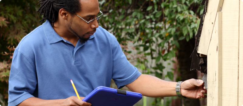 An insurance adjuster documenting roof damages.