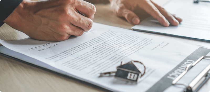 Person signing the paperwork for a new house. 