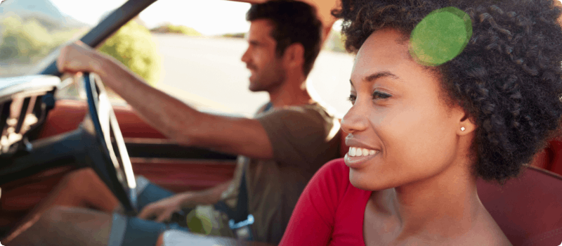 A happy couple going for a drive on a sunny day.