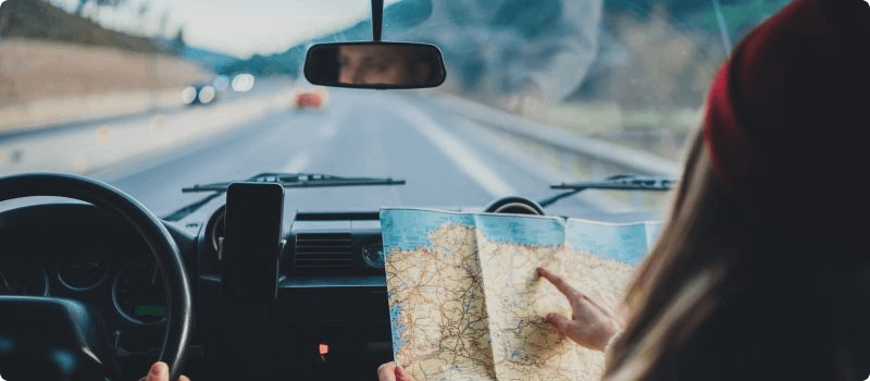 Person driving while the passenger looks at a map. 