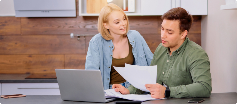 A couple reviewing documents at a table together. 