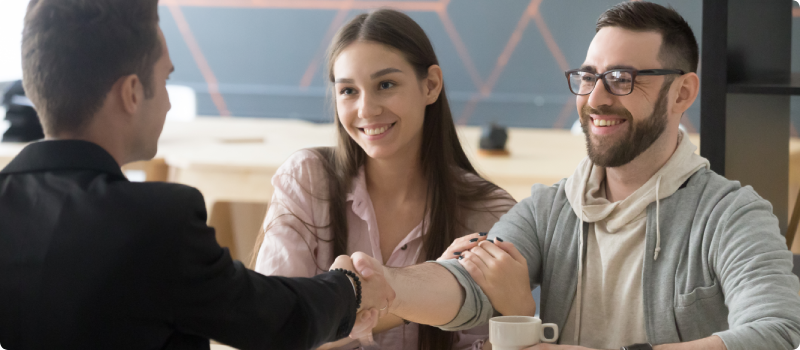 Couple shaking hands with a realtor