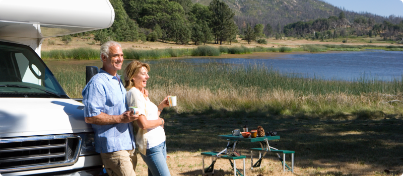 an older couple enjoying a lake outside their RV