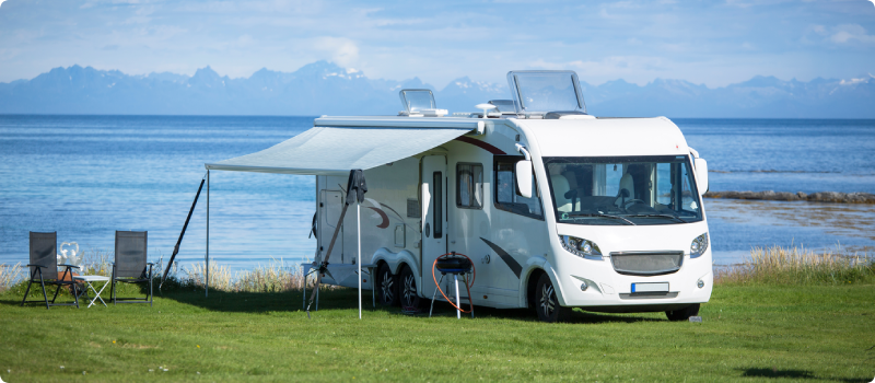 an RV parked next to a body of water
