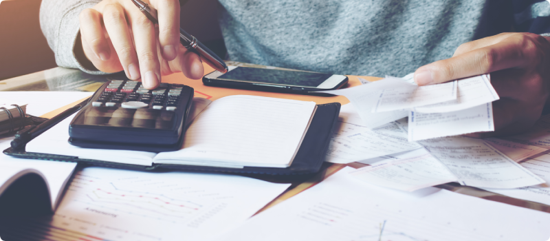 a person using a calculator to do their bills