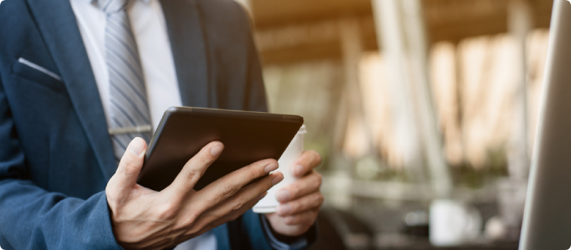 a man in a suit looking at a tablet