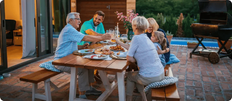 Family eating out on a patio at sunset.
