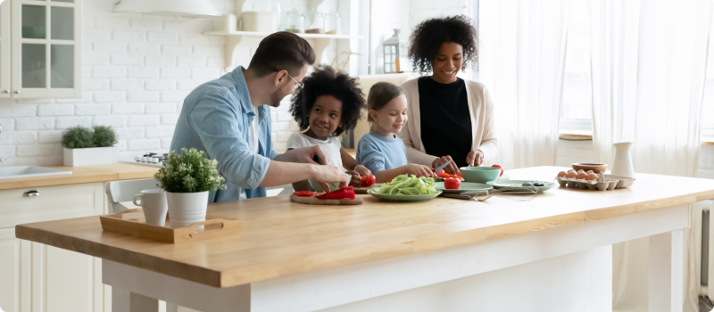 man and woman preparing food with their two daughters