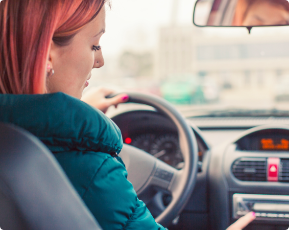 a woman adjusting her car's radio while driving