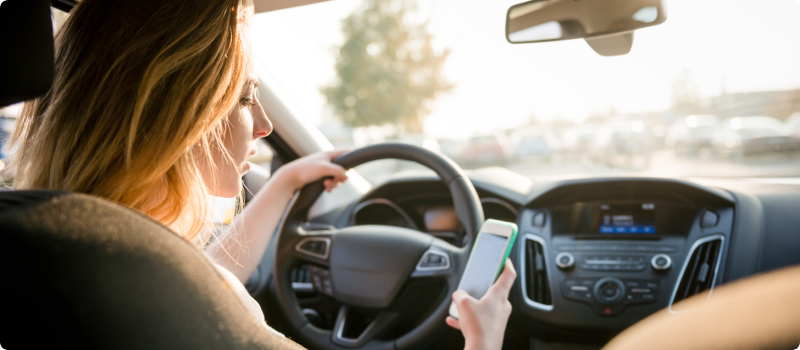 a woman looking at her phone while driving