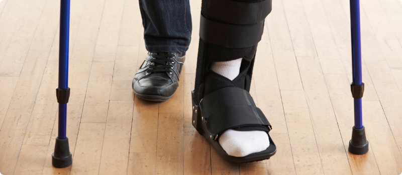 a person with a broken foot walking on crutches