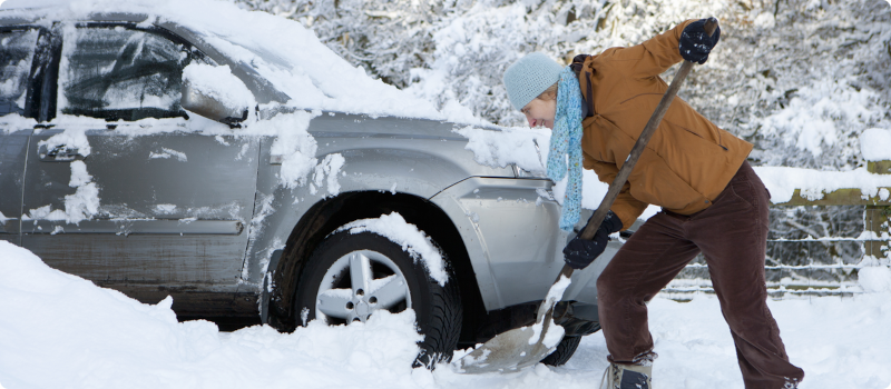 shoveling snow from around a car
