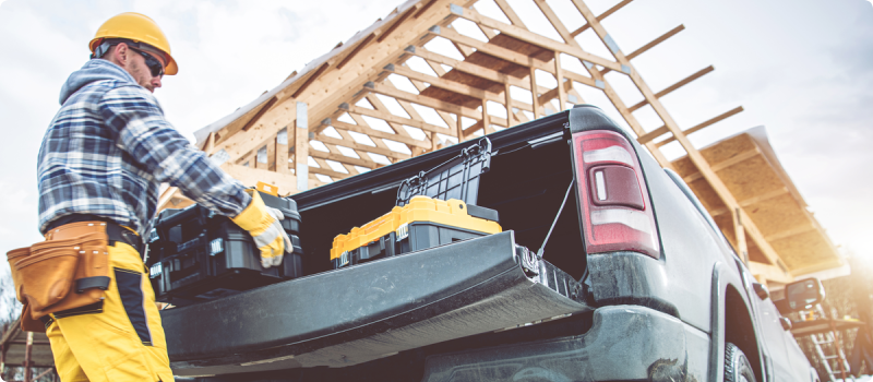 a man removing tools from his truck at a construction site