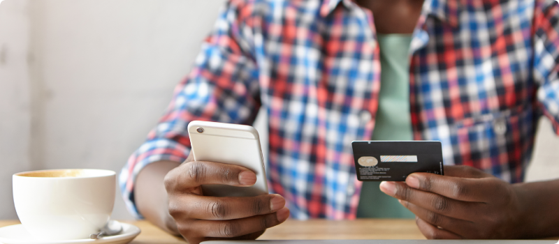 a man holding his phone and a credit card