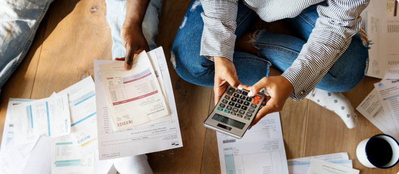 a person holding a calculator while another holds bills