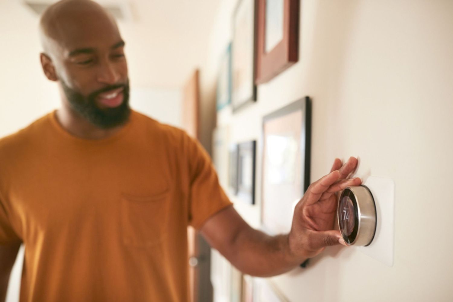 Man adjusting the thermostat in his home.