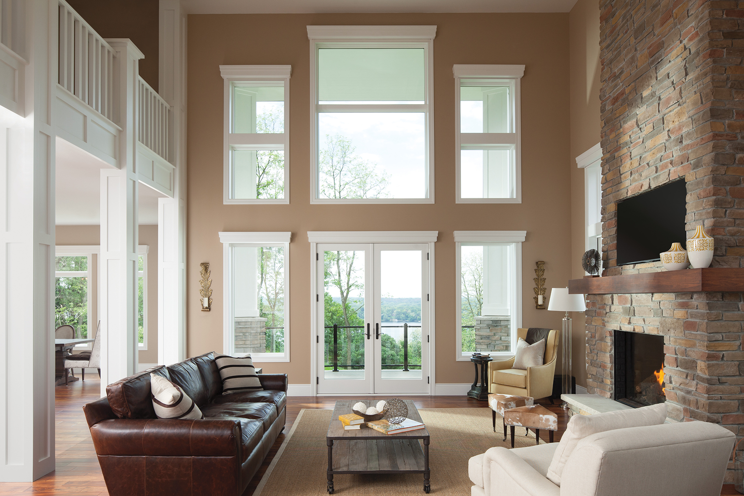 ndersen 400 Series hinged patio doors and large energy-efficient windows featured in an open-concept living room with vaulted ceilings and natural light.