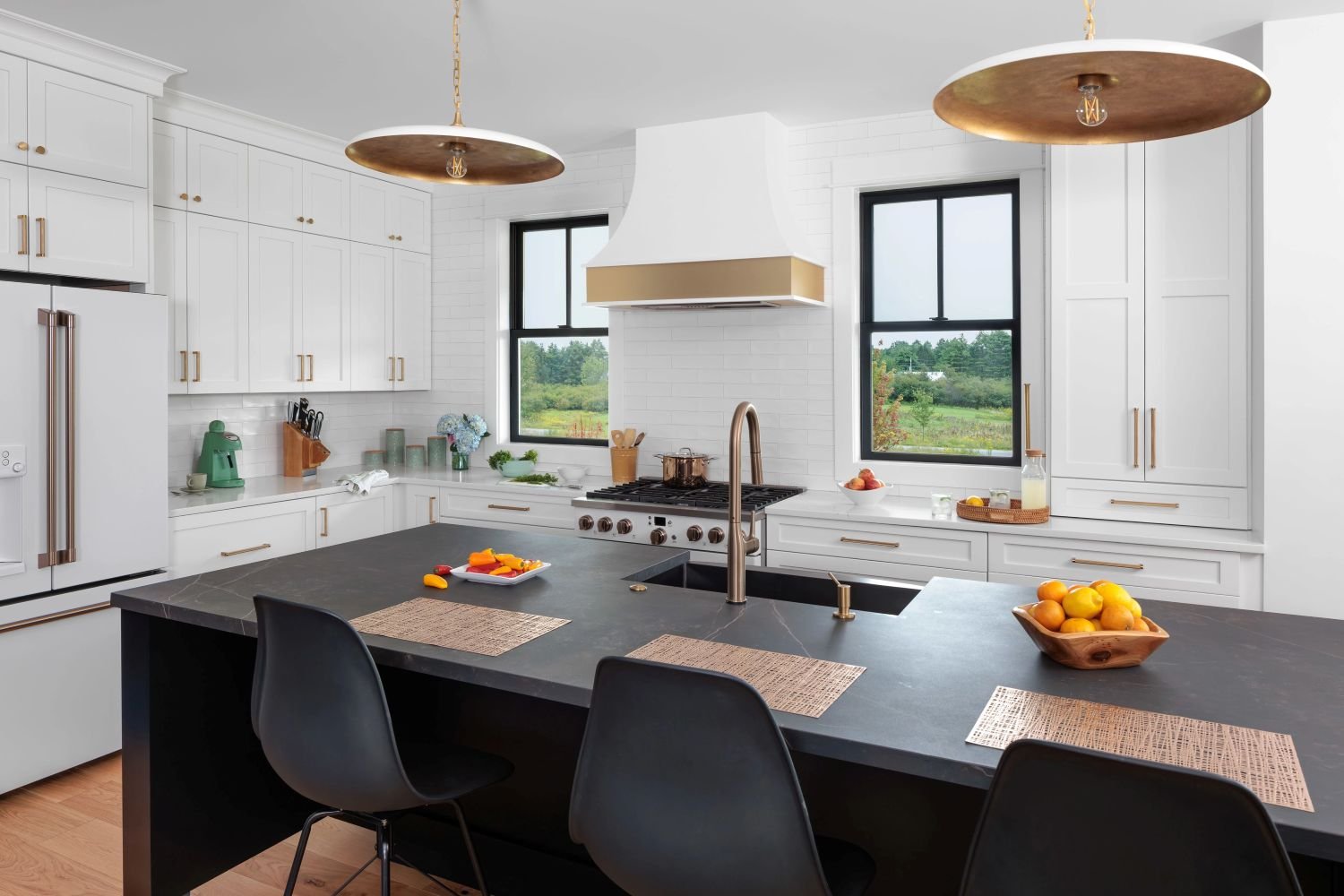 Interior shot of a kitchen with a black island and two black double hung windows