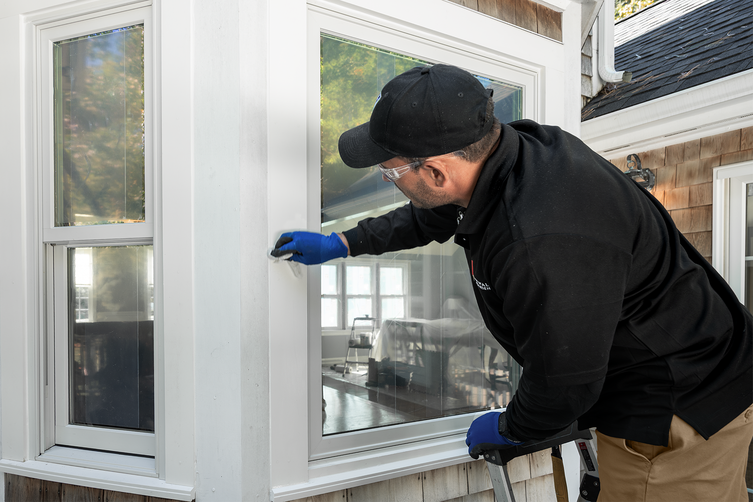 Renewal by Andersen installation service person checking on the windows