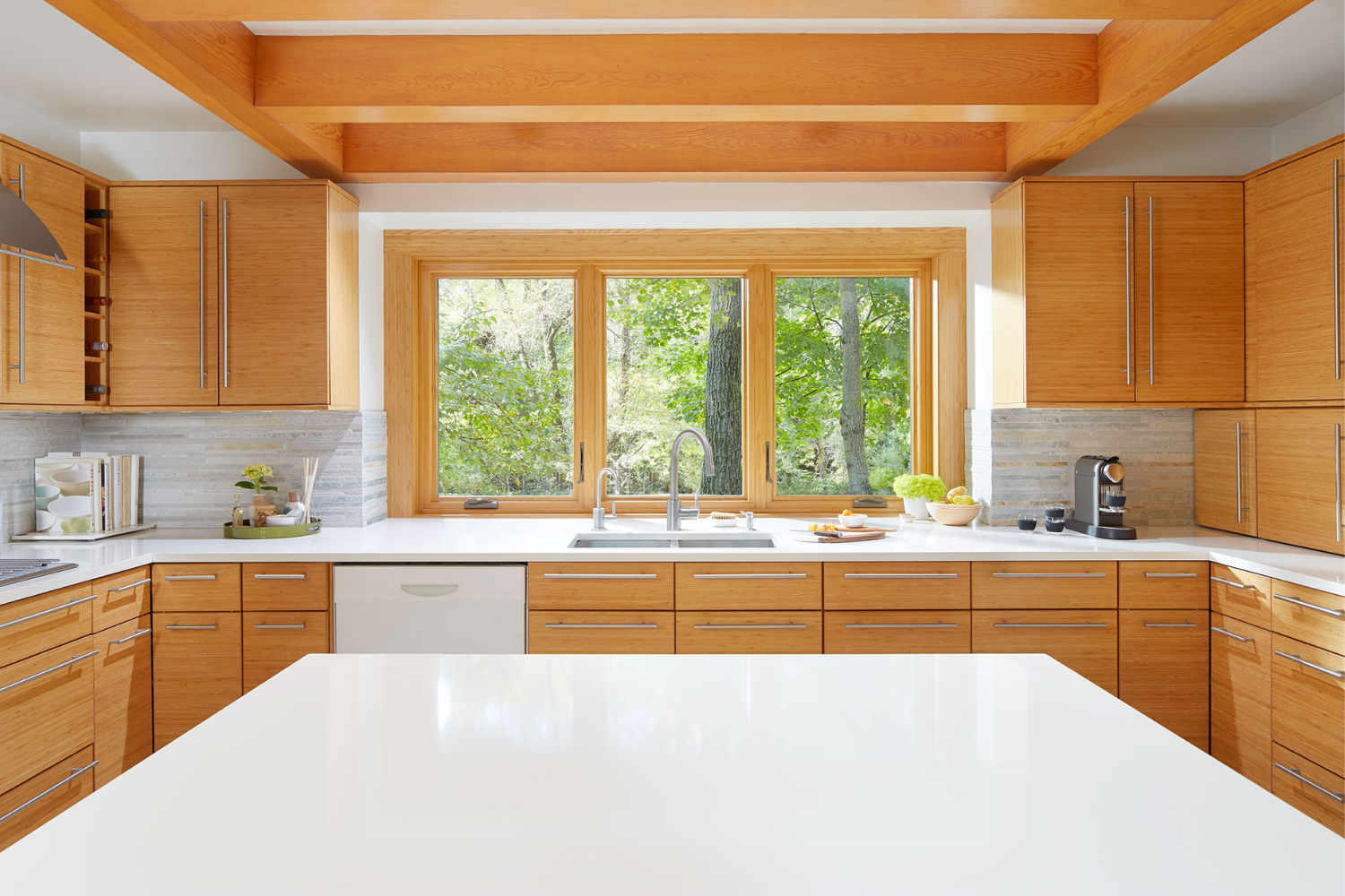 Interior shot of a kitchen island displaying brown casement windows that match the interior of kitchen cupboards