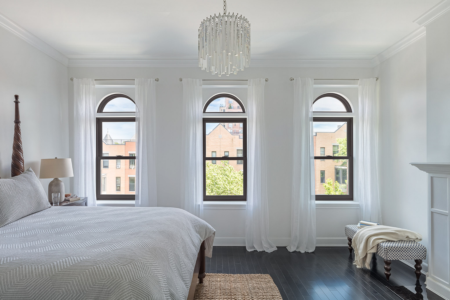 Renewal by Andersen double hung windows in a bedroom, the bed has white sheets and white walls