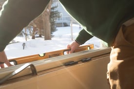 An installer working in the winter putting in replacement windows