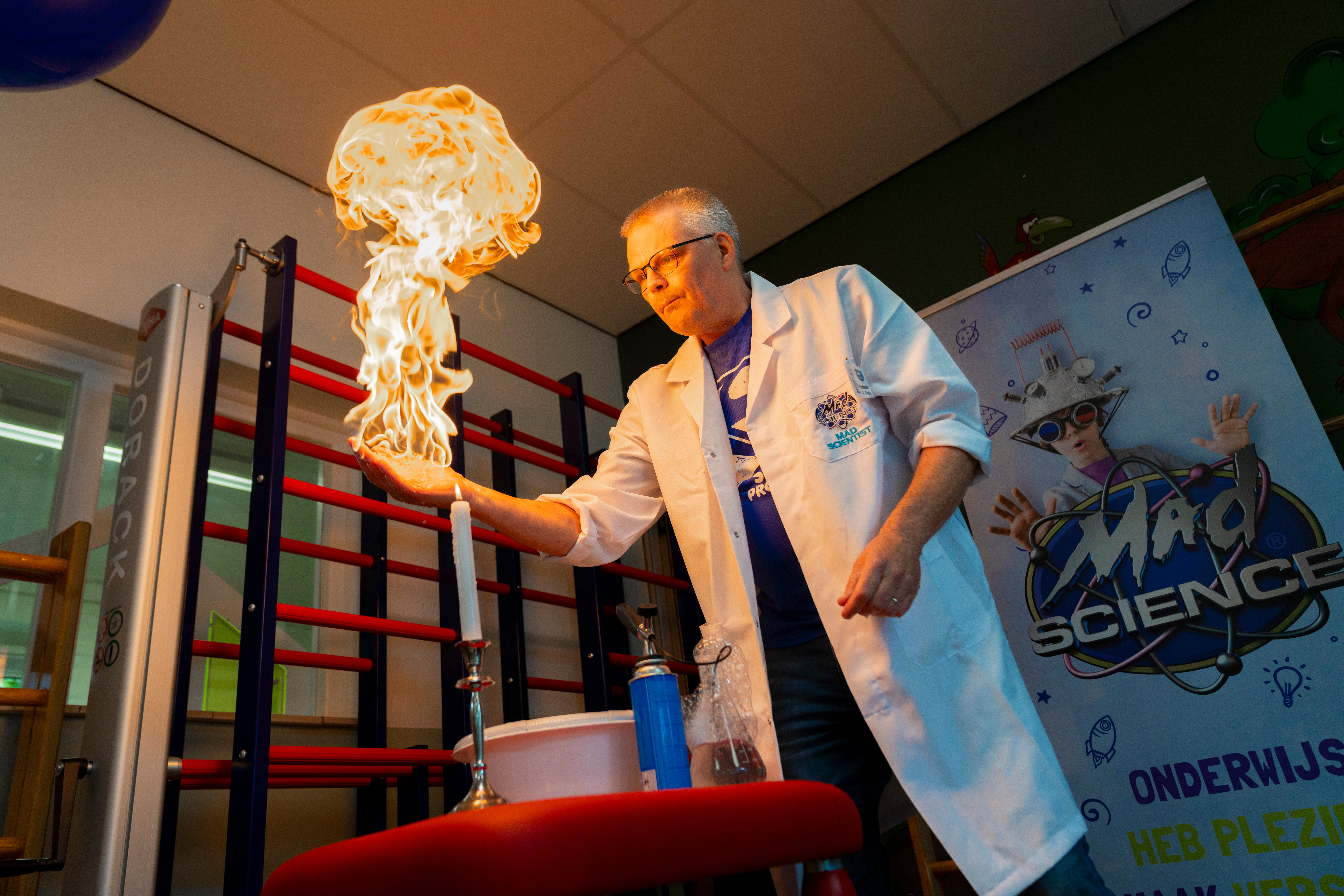 ASML Junior Academy-presentator demonstreert een vuurexperiment tijdens een wetenschapsshow.