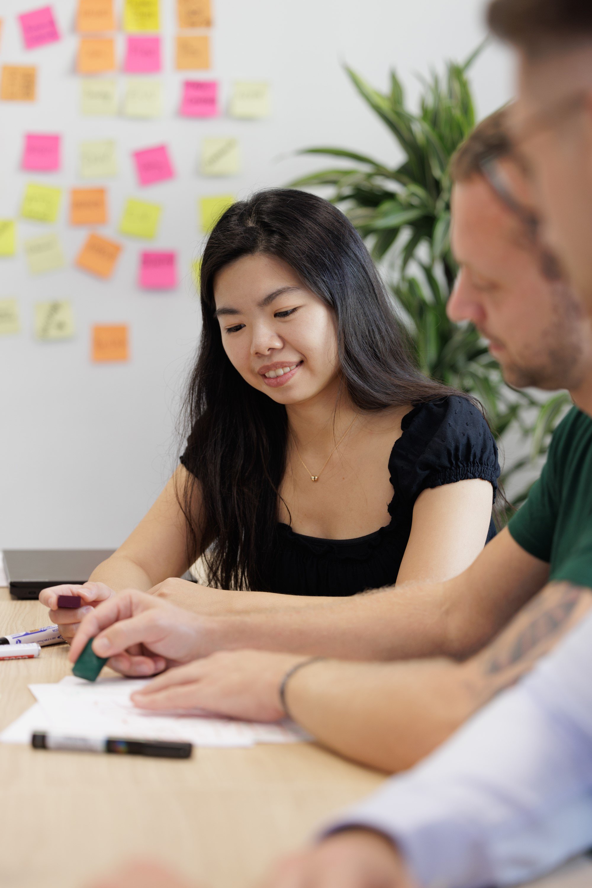 Drie studenten zijn aan het samenwerken in een kantooromgeving.