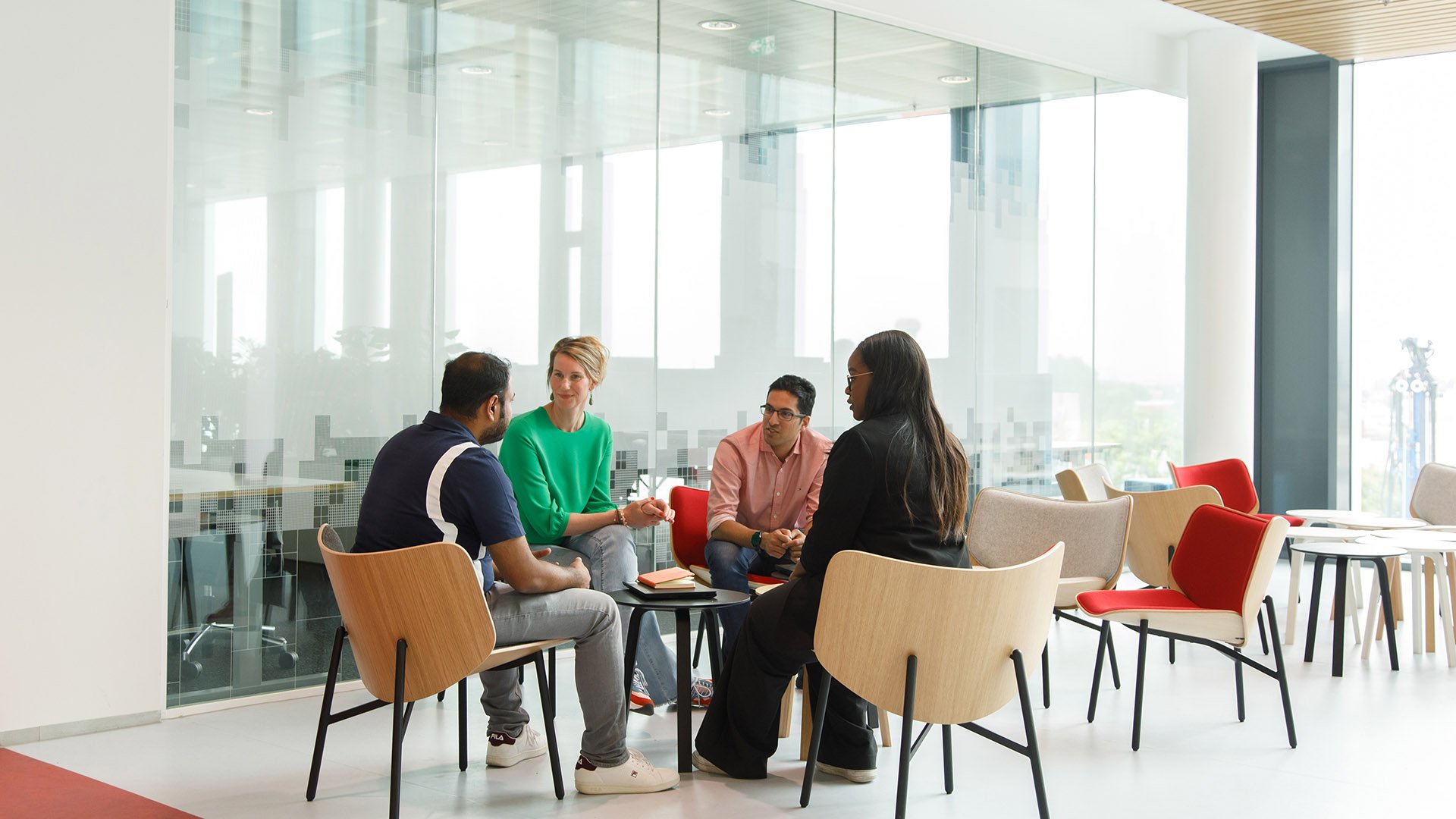 A diverse group of 4 people sit around a table in ASML Building 6 in Veldhoven, the Netherlands.