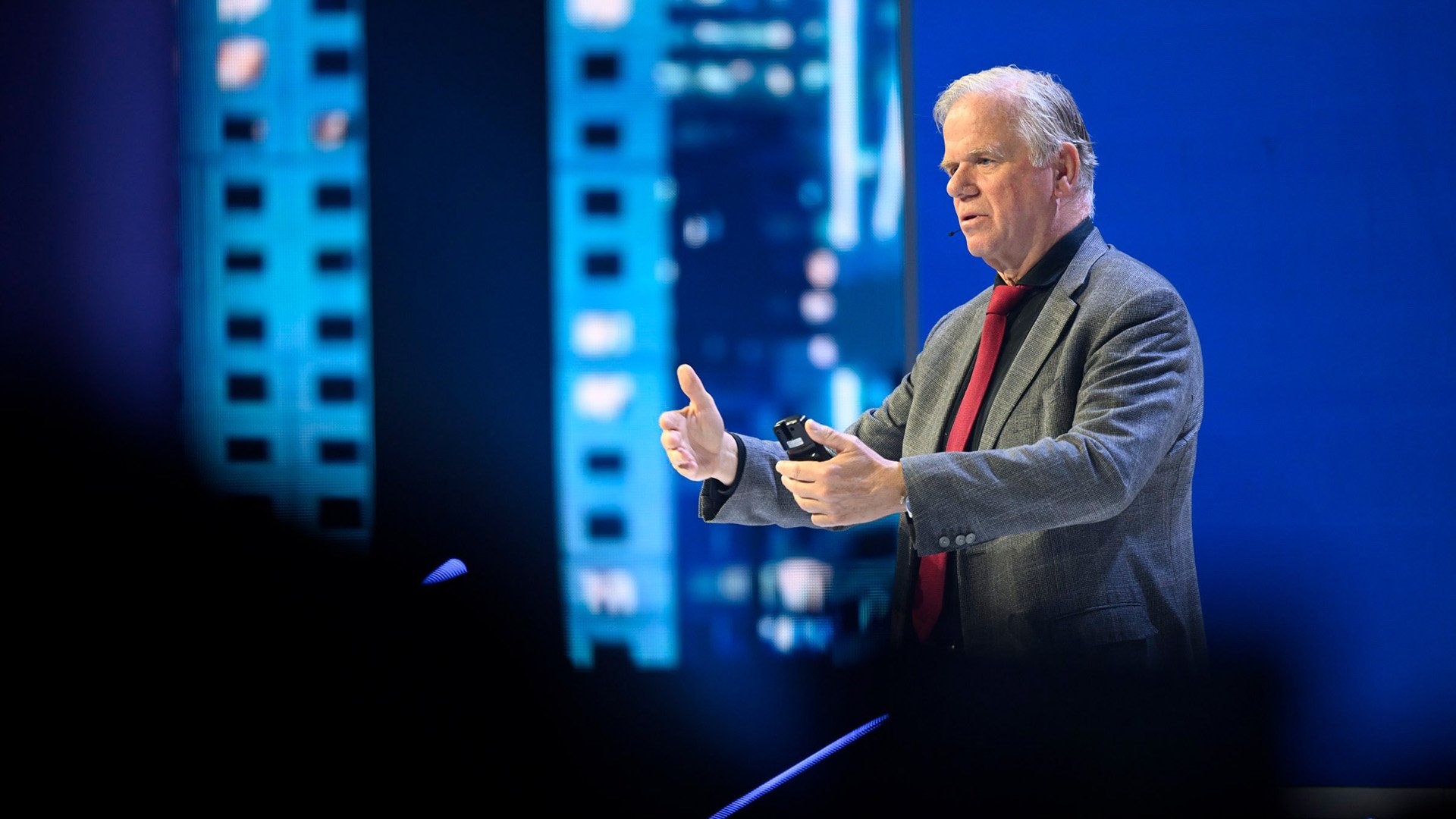 Man gesturing while speaking on a stage