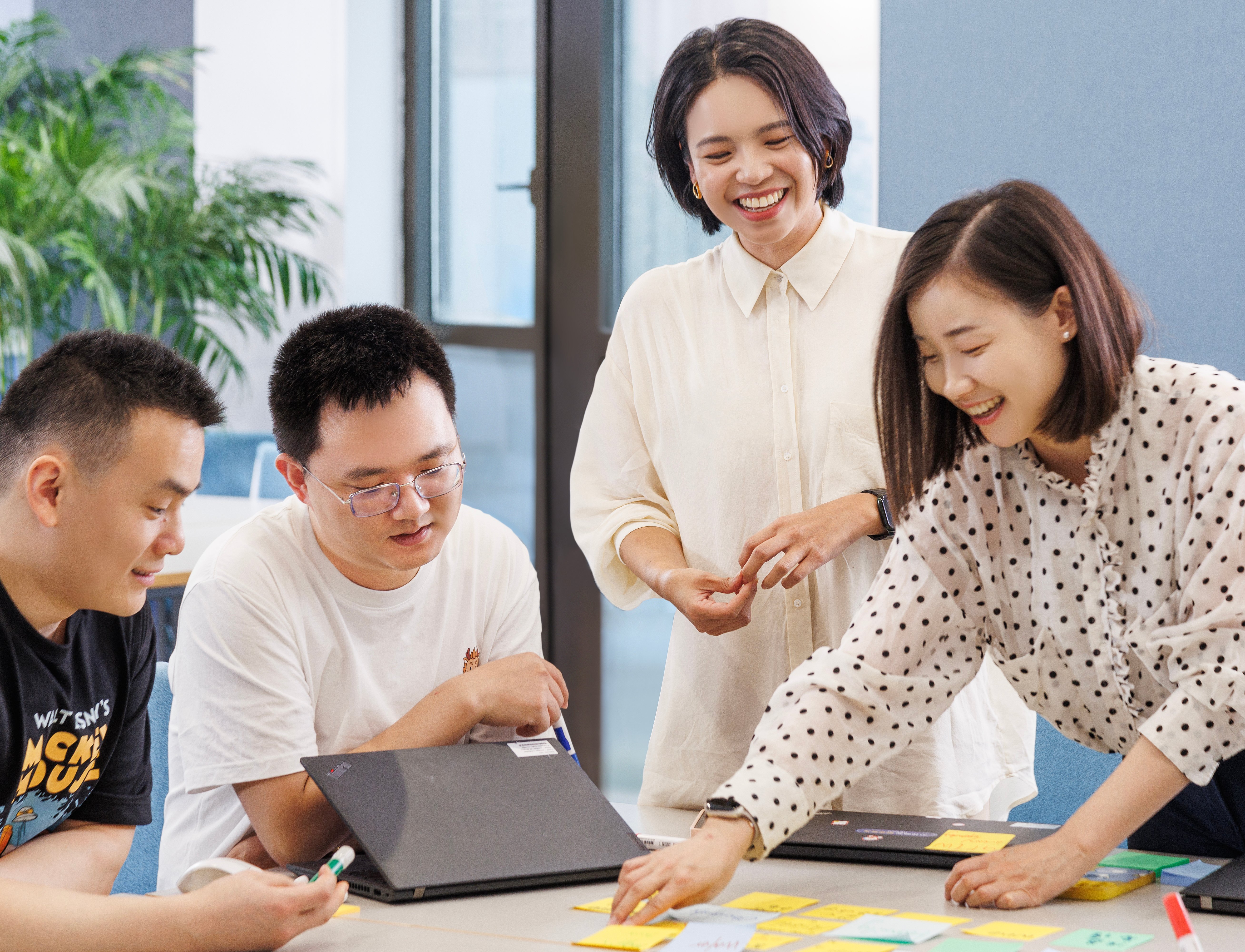 Employees collaborating using sticky notes Employees collaborating using sticky notes