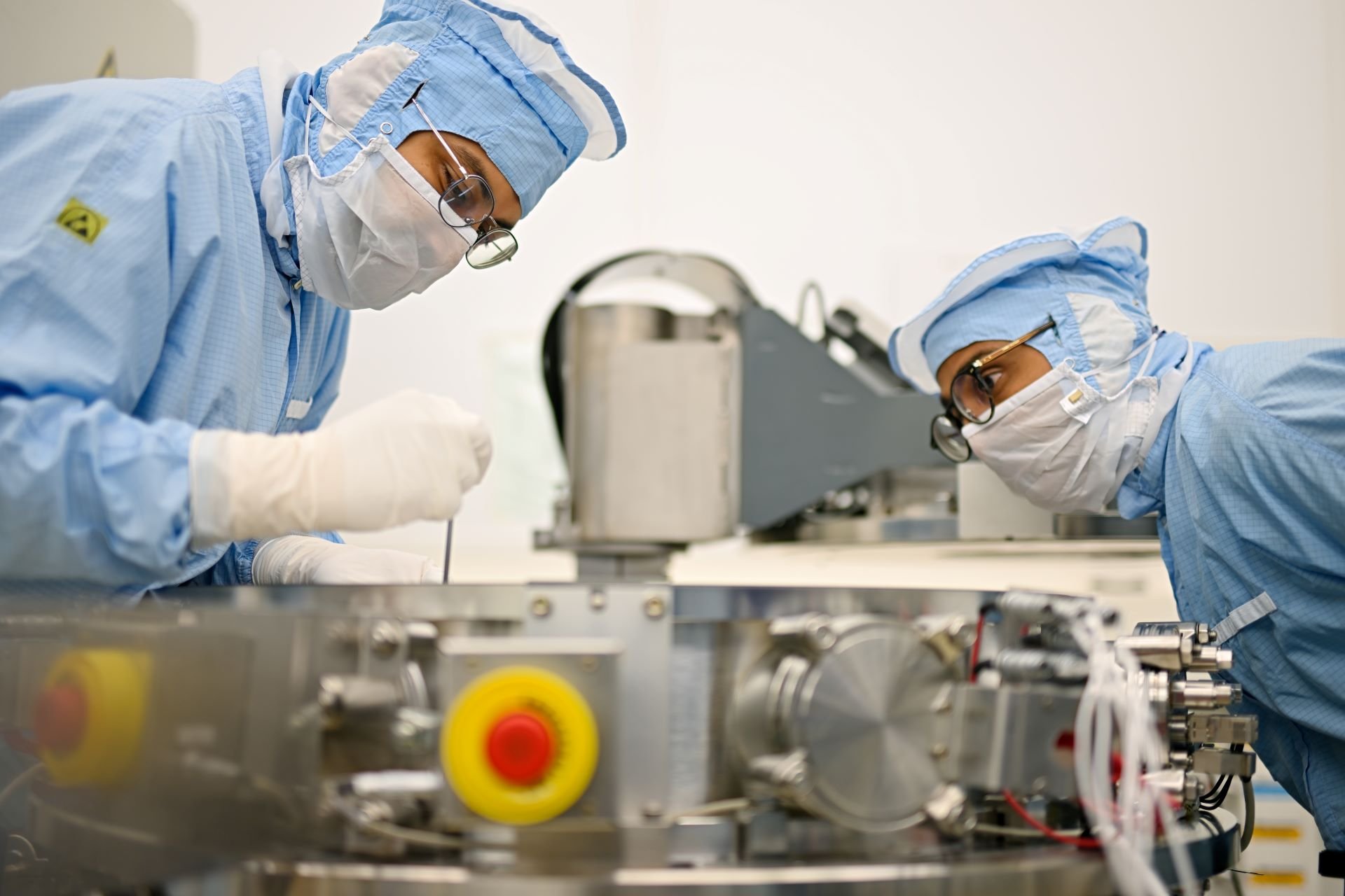 Technicians working on ASML equipment in a cleanroom