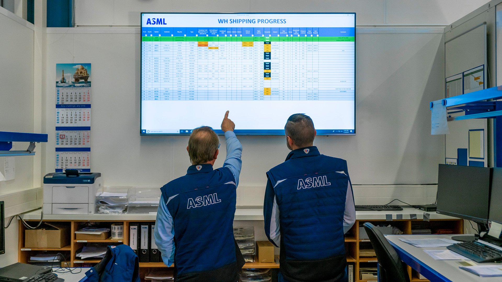 ASML employees reviewing information on a screen ASML employees reviewing information on a screen
