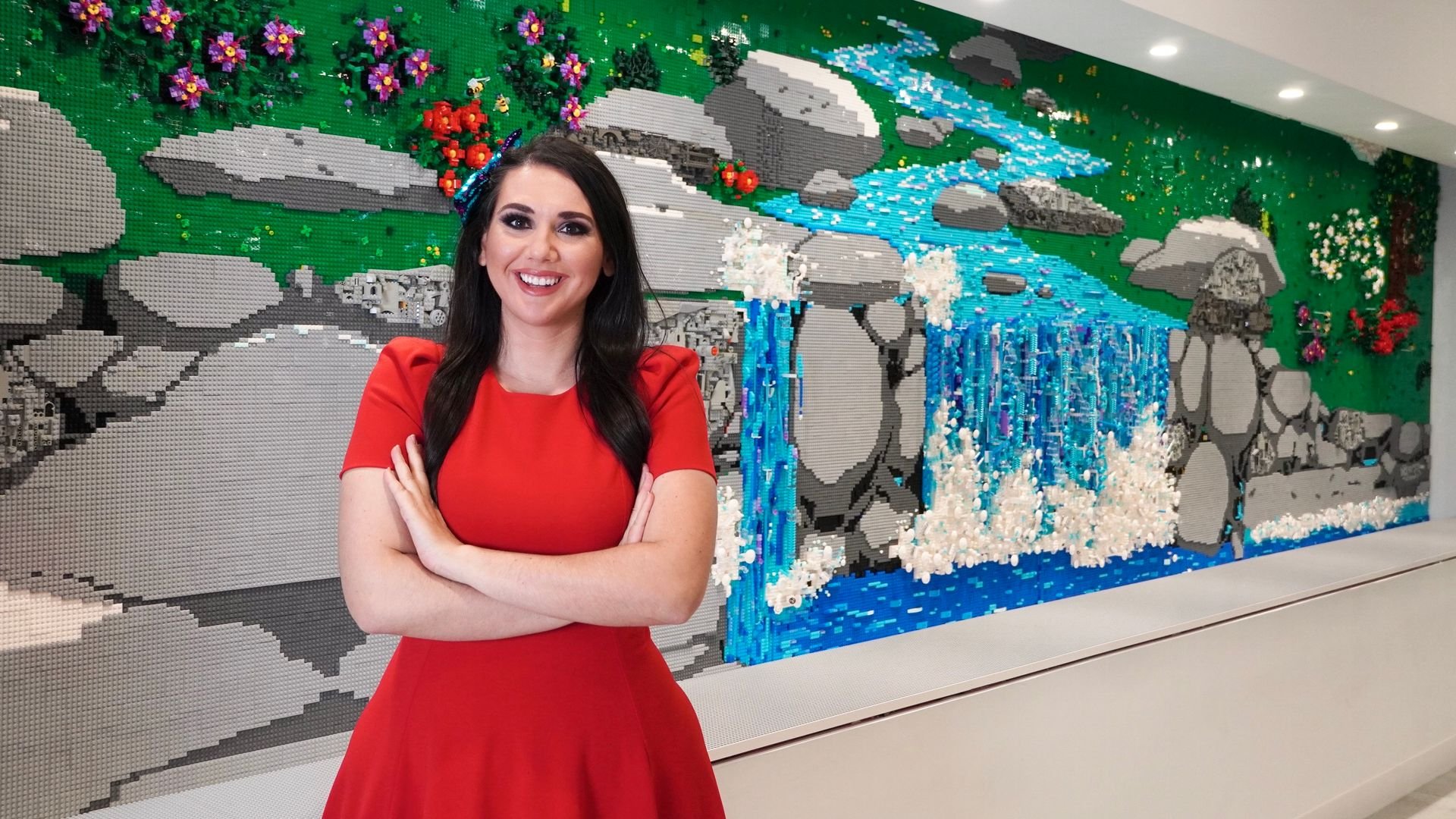 Artist, Jessica Ewud, poses with mural behind her Artist, Jessica Ewud, poses with mural behind her