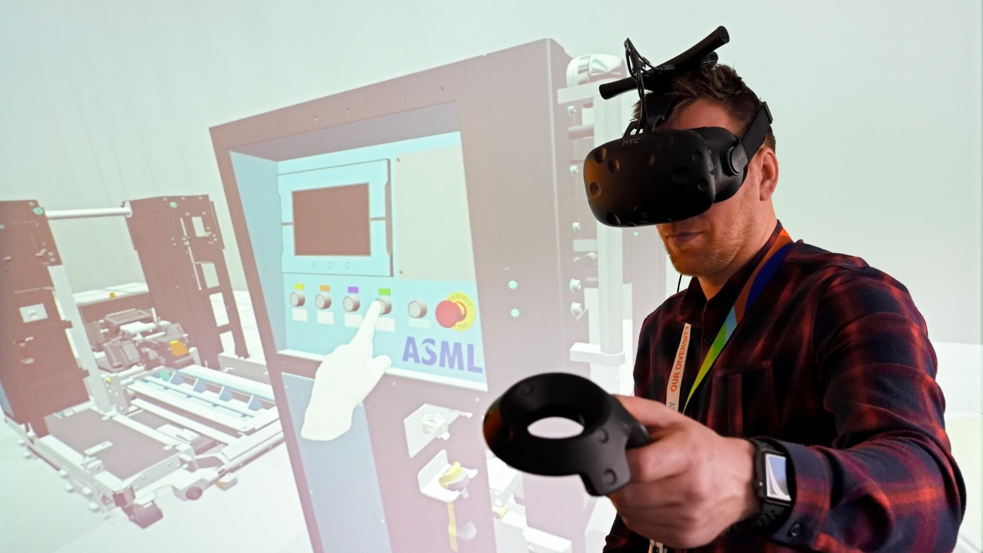 A man uses a VR headset to learn how to service an ASML lithography machine.