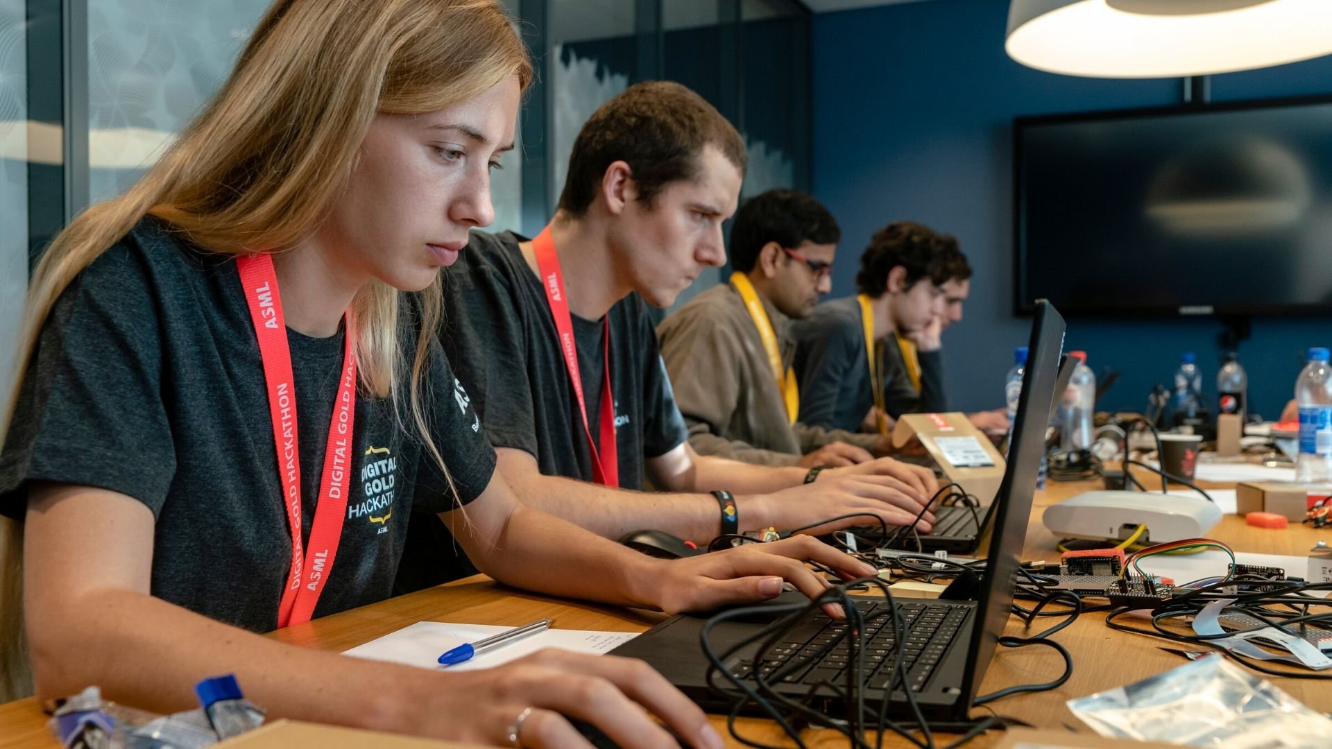 Software developers sit at a table to code during ASML's Digital Gold Hackathon in October 2018.