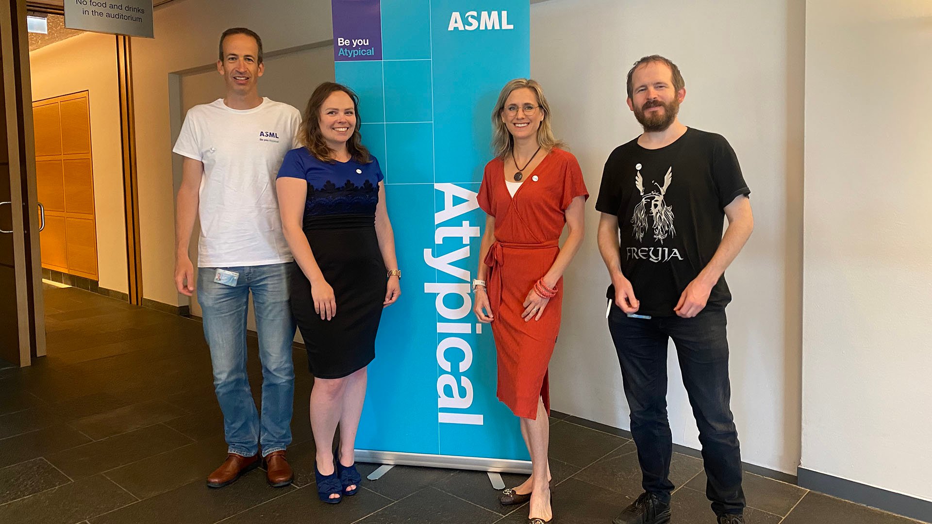ASML neurodiversity employee network board members stand next to a banner bearing the name ‘Atypical’.