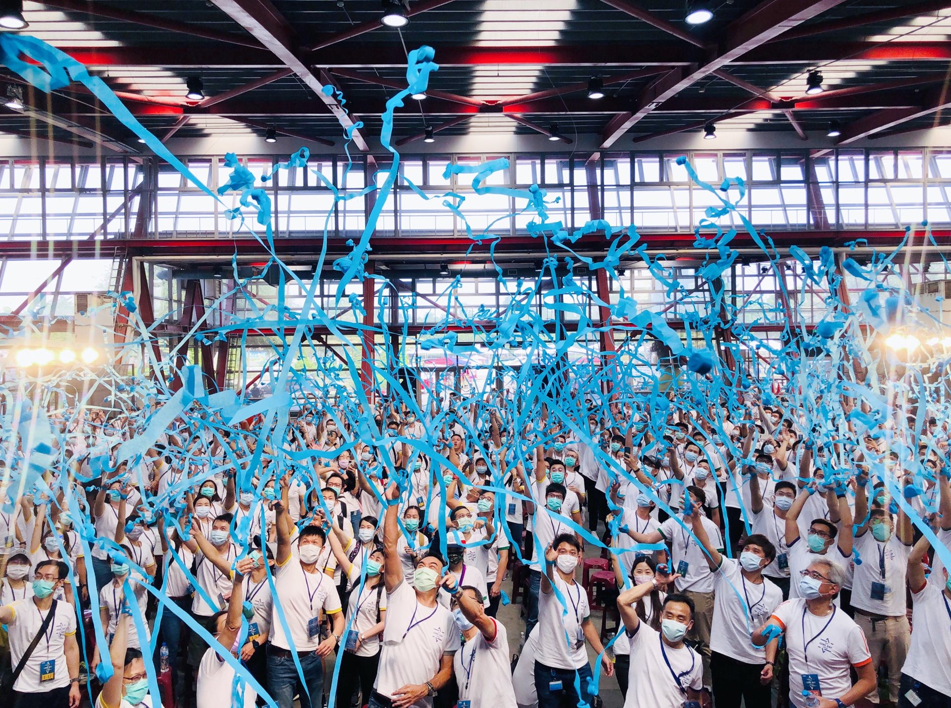 a group of employees from Taiwan let off blue streamers 