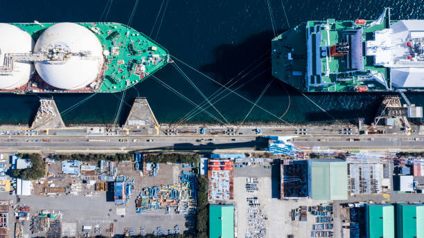 Two large ships are anchored at a port for loading and unloading supplies