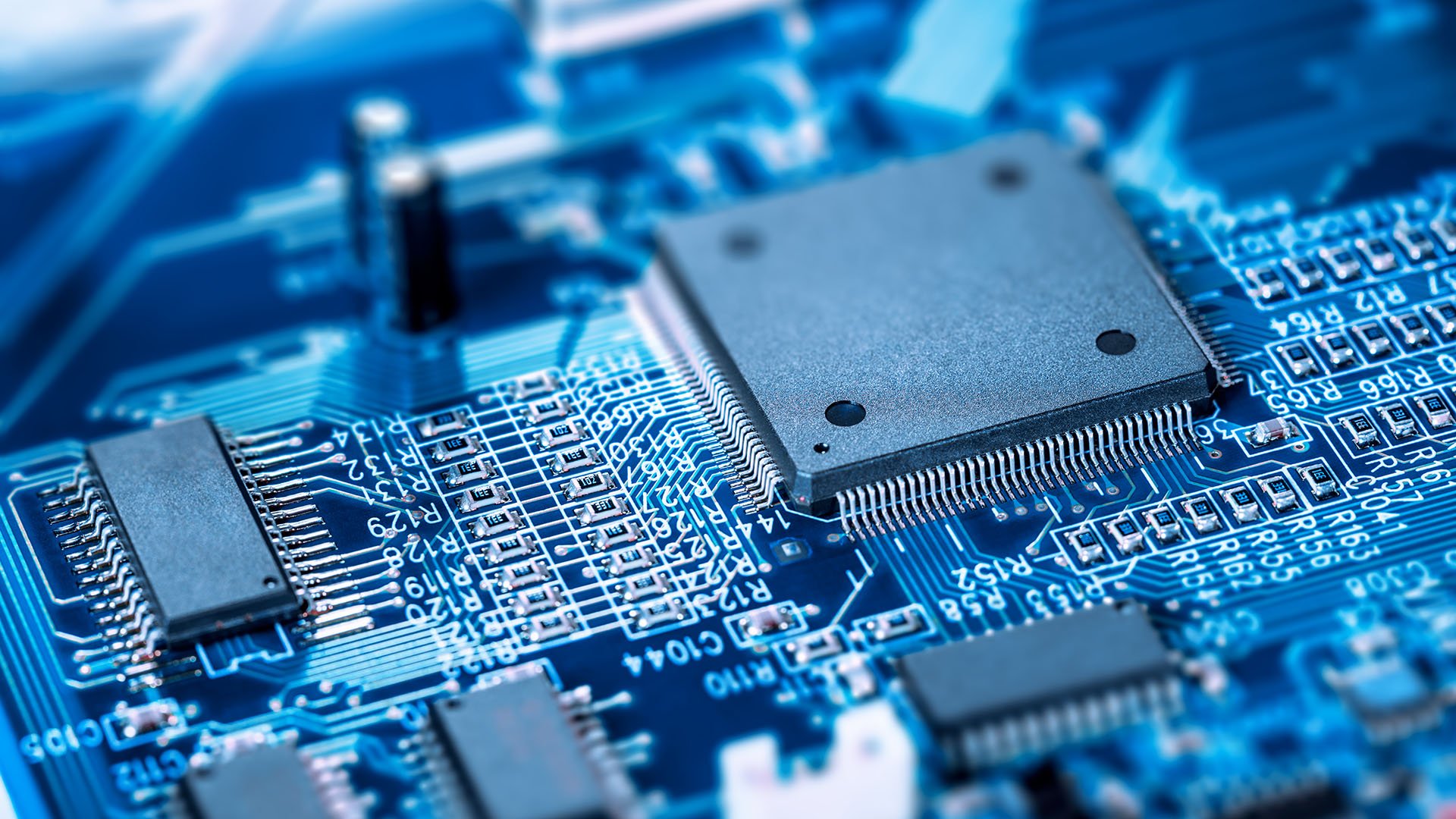 A close-up of a motherboard and circuit board with a microprocessor chip embedded. 
