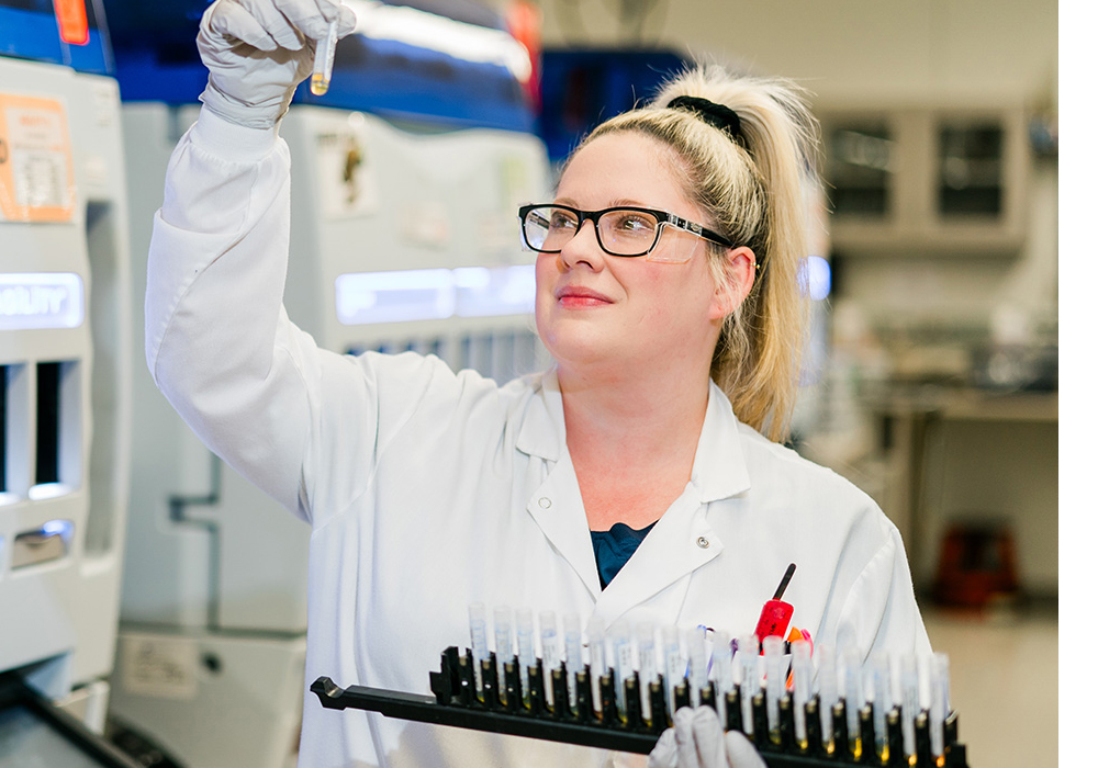 Female lab worker examining test blood vials